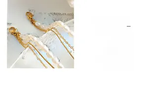 Detail of gold triple-layer bracelet with baroque pearls and lucky charm on book
