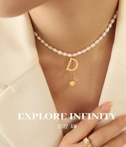 Detail of freshwater pearl necklace with gold letter D and square tassel pendant