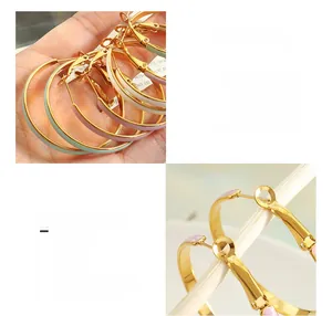 Macro view of textured titanium steel hoop earrings with colorful enamel and 18K gold plating