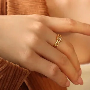 Bague chaîne dorée minimaliste avec zircon blanc sur la main d'un mannequin