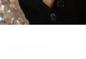 Close-up of black ribbed knit sweater neckline with two polished four-hole buttons