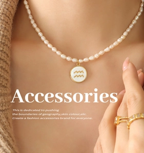 Detail of freshwater pearl necklace with gold Aquarius pendant and matching rings
