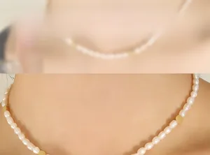 Macro view of freshwater rice pearls and golden bead accents on a layered necklace