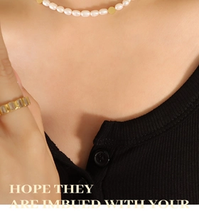 Detail of freshwater pearl necklace and gold ring with rectangle zircon on model
