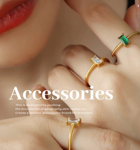 Detailed view of minimalist gold rings with white and emerald green zircon rectangles
