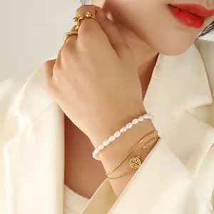 Three-layer freshwater pearl bracelet set with golden charm and rings on model
