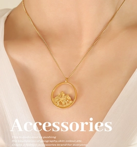 Close-up of gold mountain relief pendant necklace on model with Accessories text
