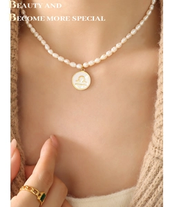 Close-up of Libra zodiac pendant necklace with freshwater pearls on a cozy knit sweater