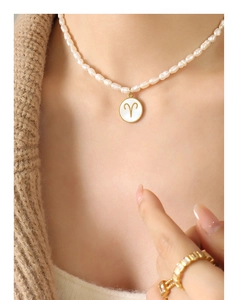 Detail of freshwater pearl necklace with Aries zodiac sign shell pendant on a model
