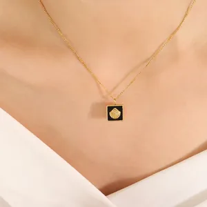 Collier doré élégant avec pendentif coquillage noir porté par un mannequin chic