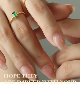 Detail of gold ring featuring a rectangular green zircon in classic four-prong setting