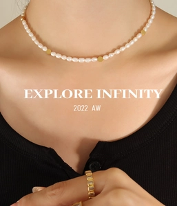 Close-up of freshwater pearl necklace with golden beads and zircon ring on model