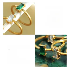 Detail of 18K gold plated titanium steel rings with emerald and clear zircon stones