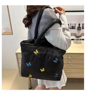 Close-up of quilted nylon tote bag featuring detailed colorful butterfly embroidery
