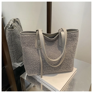 Détail du sac cabas gris en peluche montrant la fourrure synthétique et l'anse en cuir