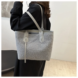 Détail du grand sac cabas en polaire grise avec anses en cuir porté à l'épaule