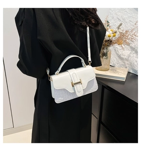 Detail of white crocodile texture handbag featuring a golden H-shaped metal buckle