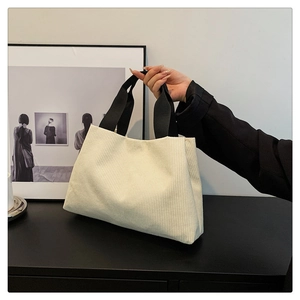 Détail d'un sac cabas en velours côtelé blanc avec larges anses noires pour femmes