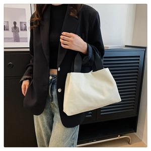 Détail du sac fourre-tout en velours côtelé blanc avec anse noire de style moderne