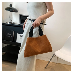 Gros plan du sac cabas en velours côtelé marron avec bandoulière noire et texture