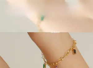 Detail of 18K gold-plated chain bracelet with emerald, amethyst and obsidian charms