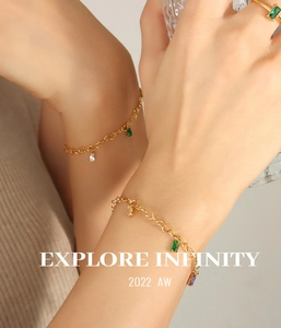 Close-up of gold-plated heart chain bracelet with colorful rectangular gemstones