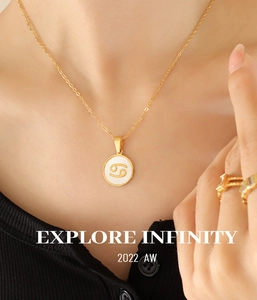 Gros plan du collier Cancer plaqué or 18 carats avec nacre blanche porté par un modèle