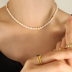 Elegant freshwater pearl necklace with gold bead accents on model neck area