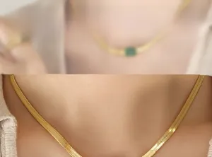 Detail of a polished golden herringbone blade chain showing the flat metal texture