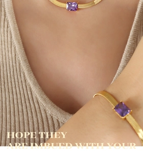 Detailed view of golden snake chain jewelry set with square purple zircon gemstones