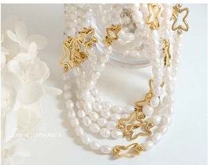 Dettaglio della collana multistrato in perle d'acqua dolce e farfalle dorate