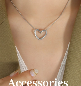 Dettaglio della collana con ciondolo a cuore argento e catena a serpente su una modella