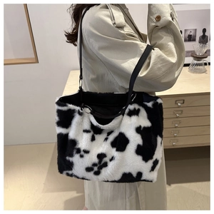 Détail d'un sac cabas en peluche à motif vache avec fourrure douce et sangle noire