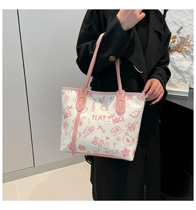 Detail of colorful graffiti tote bag with pink leather handles and cute cartoon bear print