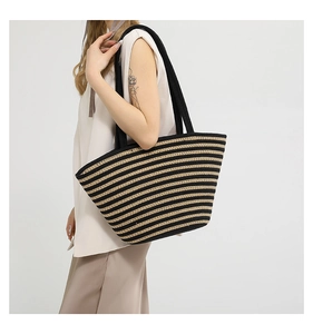 Gros plan détaillé du sac cabas en paille tissée à rayures noires et jaunes sur un mannequin