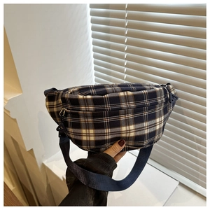 Détail du sac bandoulière à carreaux avec fermeture éclair et sangle en nylon bleu