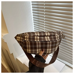 Détail d'un sac bandoulière à carreaux marron avec une sangle en nylon réglable