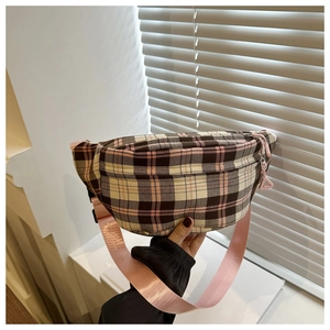 Détail du sac bandoulière à carreaux rose montrant la texture et la sangle nylon
