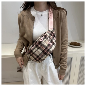 Detail of pink plaid crossbody bag featuring unique triangular zipper pulls and woven strap