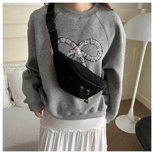 Détail du sac ceinture en velours côtelé noir avec texture rainurée et sangle ajustable