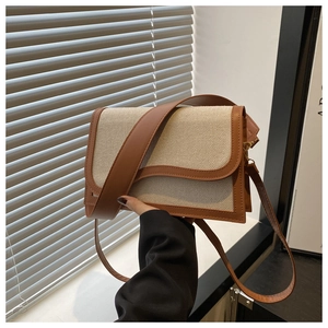 Detail of canvas shoulder bag with brown faux leather trim and dual strap options