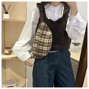 Detail of vintage brown plaid crossbody bag with nylon strap and secure buckle
