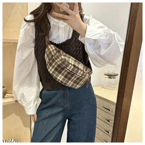 Mirror selfie showing a woman wearing a retro plaid crescent crossbody bag with casual outfit