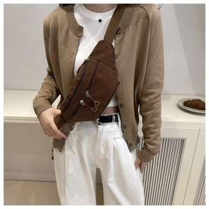 Detail of dark brown corduroy waist bag with textured stripes and metal zippers
