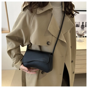 Détail du rabat asymétrique en forme de vague sur ce sac bandoulière en cuir noir