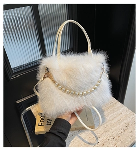 Detailansicht der weißen Kunstfell-Handtasche mit eleganter Perlenkette und Textur