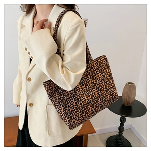 Detailed view of a large leopard print tote bag styled in a minimalist interior setting