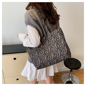 Detail view of large leopard print tote bag in durable canvas shown on shoulder
