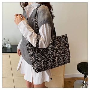 Side view of large leopard print canvas tote bag showing the draped shape and texture