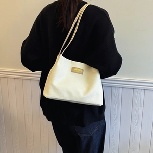 Stylish waffle texture cream shoulder bag with brown leather tag for casual commute